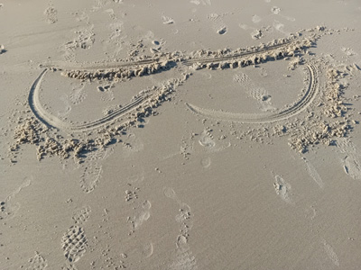 painting in the sand, breasts with the cuts marked for the mastectomy